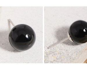 Macro view of S925 sterling silver stamp and polished black agate ball stud earrings