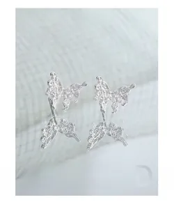 Macro detail of S925 silver butterfly earrings with a liquid lava metal texture finish