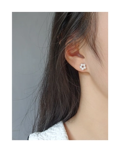 Model wearing elegant flower-shaped pearl stud earrings crafted from S925 sterling silver