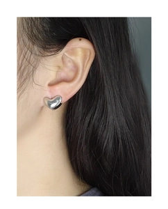 Close-up of S925 sterling silver geometric heart earrings worn by a model