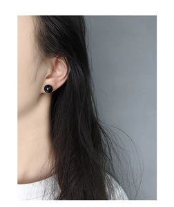 Close-up of minimalist black onyx sphere stud earrings worn by a model in S925 silver