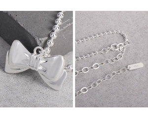 Macro view of S925 sterling silver bow pendant and adjustable beaded chain detail