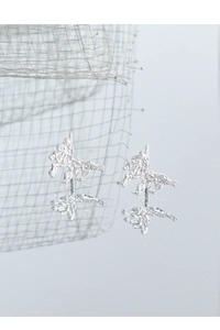 Macro view of silver horse earrings with unique textured lava finish and mirror reflection