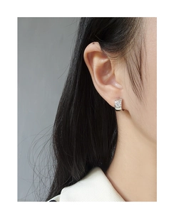 Close-up of S925 silver hoop earring with heart-shaped zircon on model ear