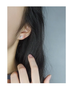 Close-up of S925 silver butterfly stud earring with irregular molten texture on ear