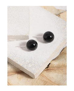 Macro shot of minimalist S925 sterling silver black agate ball stud earrings on stone