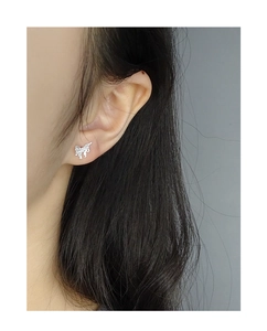 Close-up of textured silver butterfly stud earring made of S925 sterling silver on ear