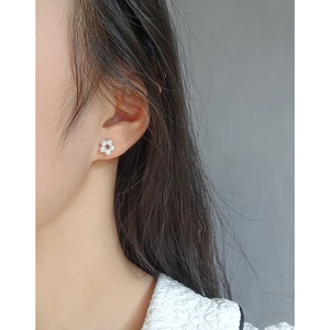 Elegant S925 silver floral pearl stud earrings worn by a model for a minimalist look