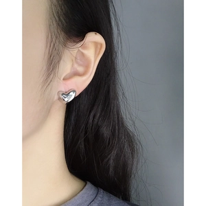 Minimalist S925 sterling silver heart-shaped stud earrings shown on model ear
