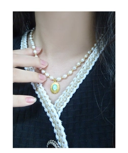 Détail d'un collier de perles en argent S925 avec pendentif opale soleil doré