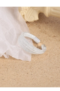 Macro detail of silver multi-layer woven texture ring with smooth cylindrical ends
