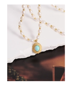 Détail du pendentif soleil vintage avec opale ovale et perles d'eau douce sur chaîne
