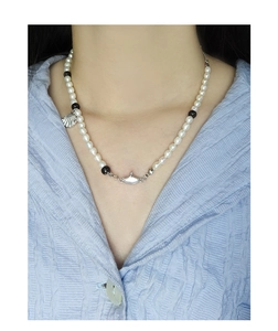 Détail du pendentif coquillage en argent S925 et agate sur un collier de perles blanches