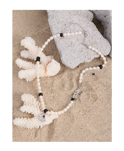 Détail du pendentif coquillage S925 et perles naturelles sur décor de sable