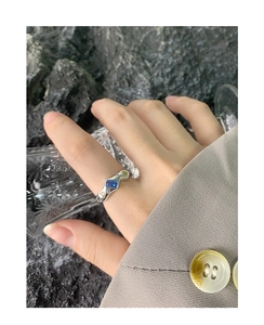 Nahaufnahme eines S925 Silberrings mit blauem Zirkon und grünen Steinen an der Hand