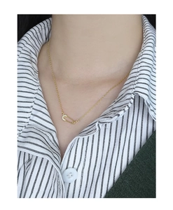 Nahaufnahme der goldenen Sicherheitsnadel-Halskette mit funkelnden Micro-Pave-Kristallen