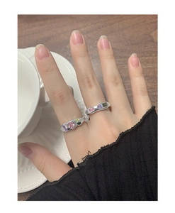 Close-up of S925 silver rings with colorful heart-shaped zircon stones on a model's hand