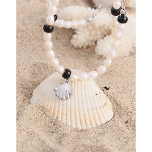 Collier en argent S925 avec perles blanches et pendentif coquillage sur fond de sable