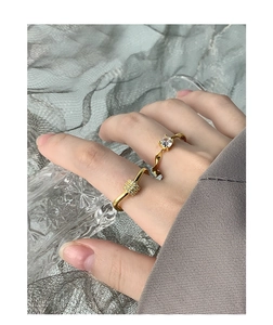 Detail of two gold plated sterling silver rings with zircon settings on model hand