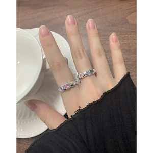 Hand wearing silver S925 wave rings with colorful zircons in a lifestyle setting