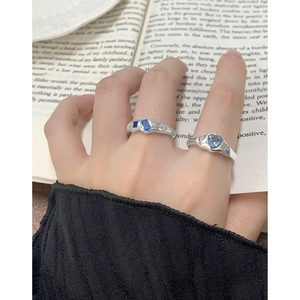 Bagues en argent S925 avec zircons bleus et violets portées sur la main du modèle