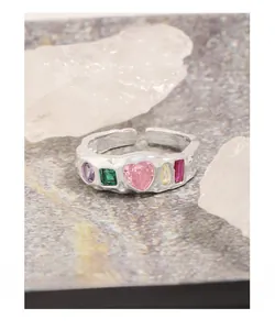 Macro shot of silver lava texture ring with five multi-color gemstones and heart center