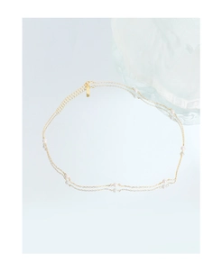 Close-up of a double-layer gold chain necklace with small pearls and a lobster clasp