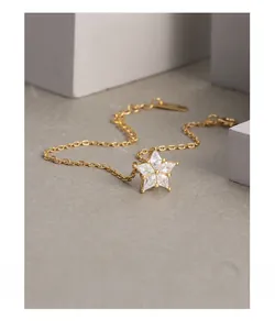 Detailed shot of a gold-plated snowflake bracelet with sparkling zircon stones