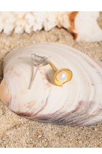Macro shot of S925 silver shell pearl earrings on a natural sandy beach background
