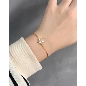 Elegant gold snowflake bracelet with sparkling zircons on a model's wrist