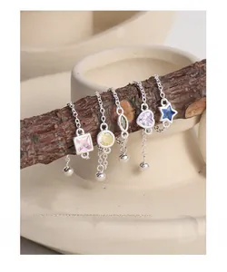 Detail of adjustable S925 silver chain rings with colorful zircon gems on a wooden branch