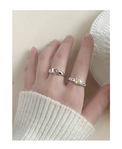 Detailed view of S925 silver rings with pink heart and yellow star zircon stones on hand