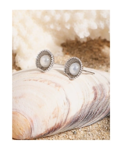 Macro shot of S925 sterling silver shell earrings with pearls on natural beach sand