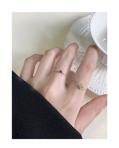 Close-up of S925 sterling silver soft chain rings with green and yellow gemstones