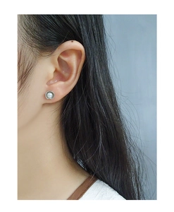 Close-up of S925 silver shell texture pearl stud earrings worn by a model