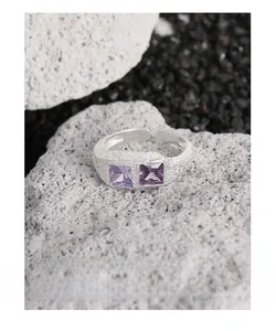 Dettaglio macro dell'anello in argento S925 con zirconi viola e texture lava martellata