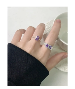 Dettaglio di anelli in argento S925 con zirconi viola rettangolari e fascia testurizzata
