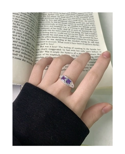 Dettaglio dell'anello in argento S925 con pietre di zircone viola su un libro aperto