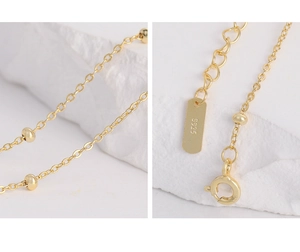 Detailed macro view of S925 sterling silver stamp and spring clasp on golden chain