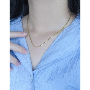 Elegante goldene flache Schlangengliederkette aus S925 Sterlingsilber getragen am Hals