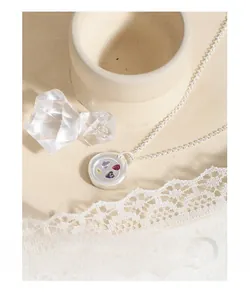 Detail of S925 silver necklace with circular pendant set with colorful heart gemstones
