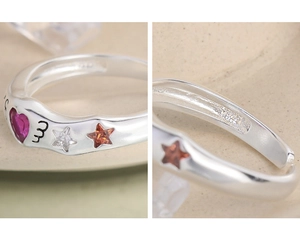 Detailed macro view showing the S925 hallmark and pink heart-shaped stone on the silver ring