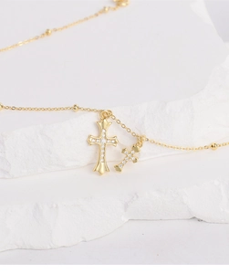Detailed view of gold S925 silver double cross pendant necklace with zircon stones