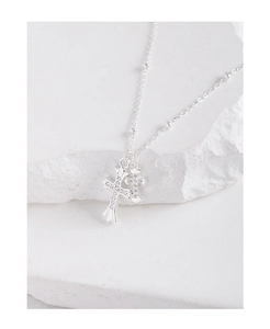 Detailed view of silver layered cross pendants with pavé zircons on a delicate chain