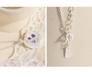 Macro detail of S925 silver necklace with four colorful heart-shaped zircon stones
