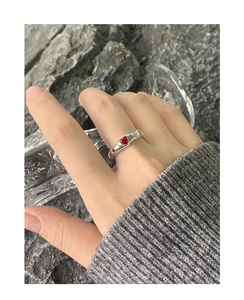 Detail of silver S925 ring featuring a red heart gemstone and engraved wings pattern