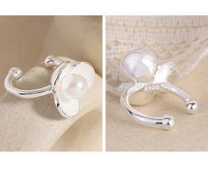 Detail of S925 sterling silver ear cuff with white enamel petals and central pearl inlay
