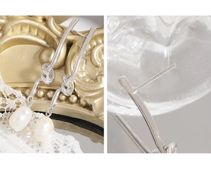 Detail of S925 sterling silver stamp and white freshwater pearls on knotted stud earrings