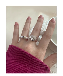 Gros plan de bagues en argent en forme de cœur avec zircon rose et pierres colorées