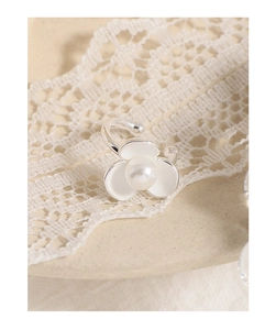 Detailed macro view of S925 silver flower ear cuff with white enamel petals and pearl center
